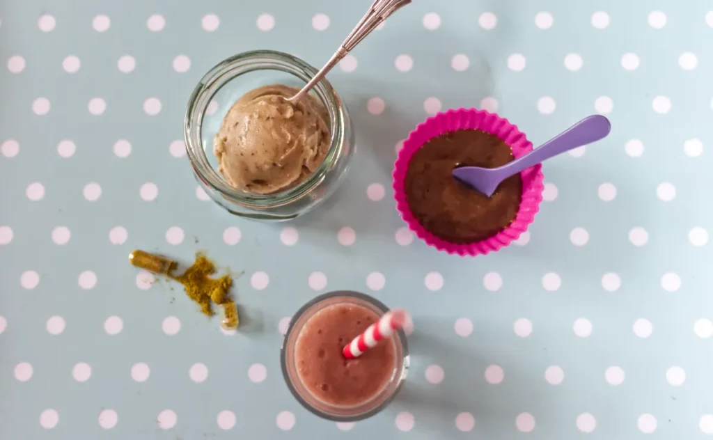 Smoothie, ice cream jar, chocolate bowl and turmeric capsules overhead