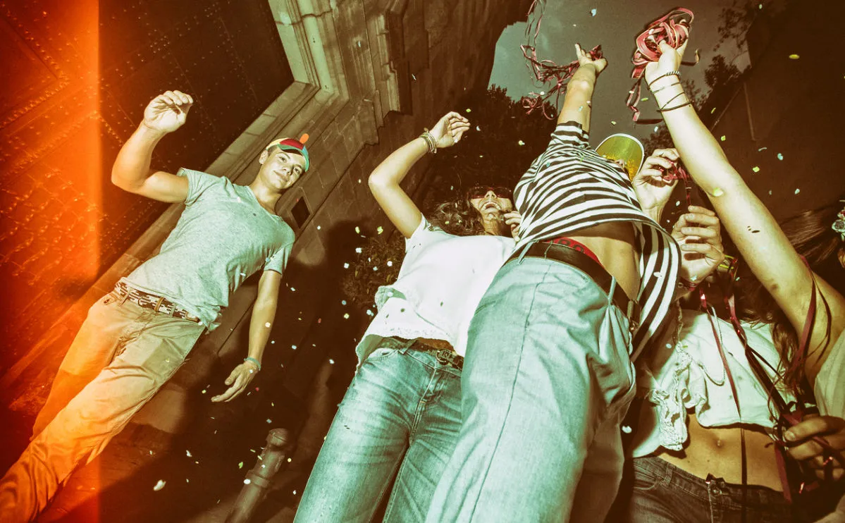 teenagers dancing at a party, holding streamers