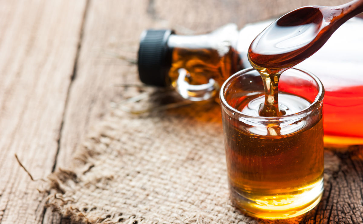 Maple syrup in glass bottle on a wooden table