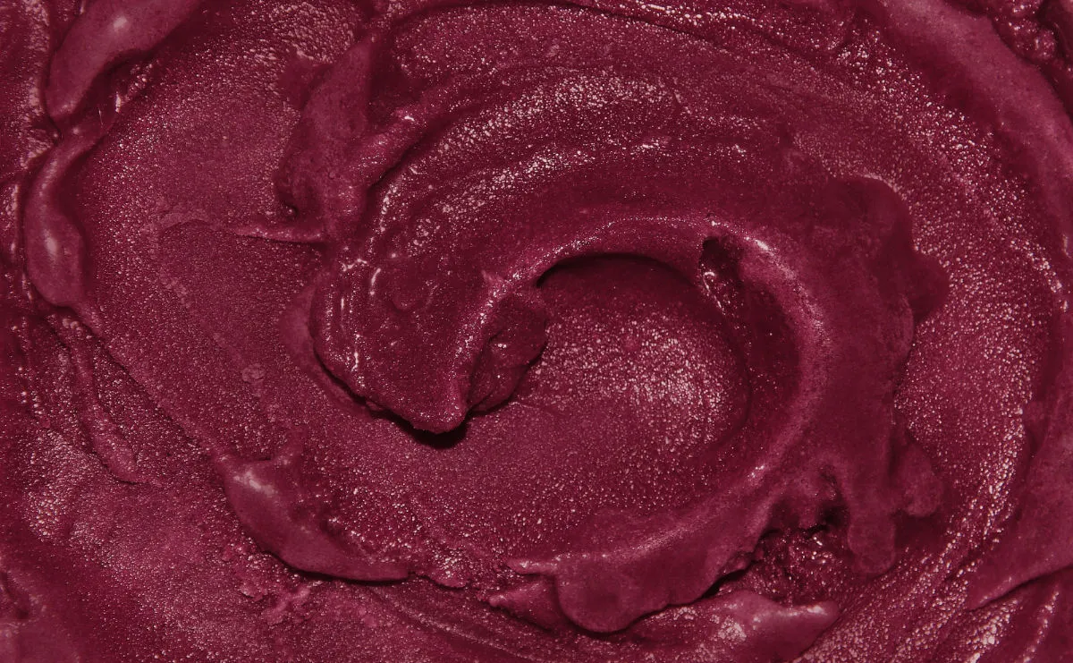 Close-up of smooth, dark purple Acai swirled in a circular pattern, showing a creamy, slightly glossy texture.