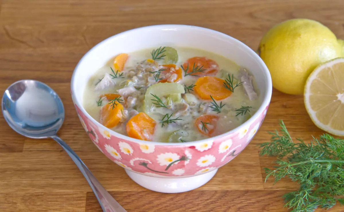 Bowl of vegetable soup with dill and lemon