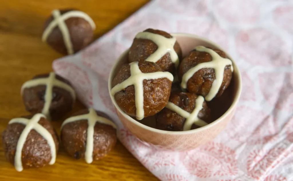 Little hot cross bun style balls in a pink bowl on a pink and white napkin