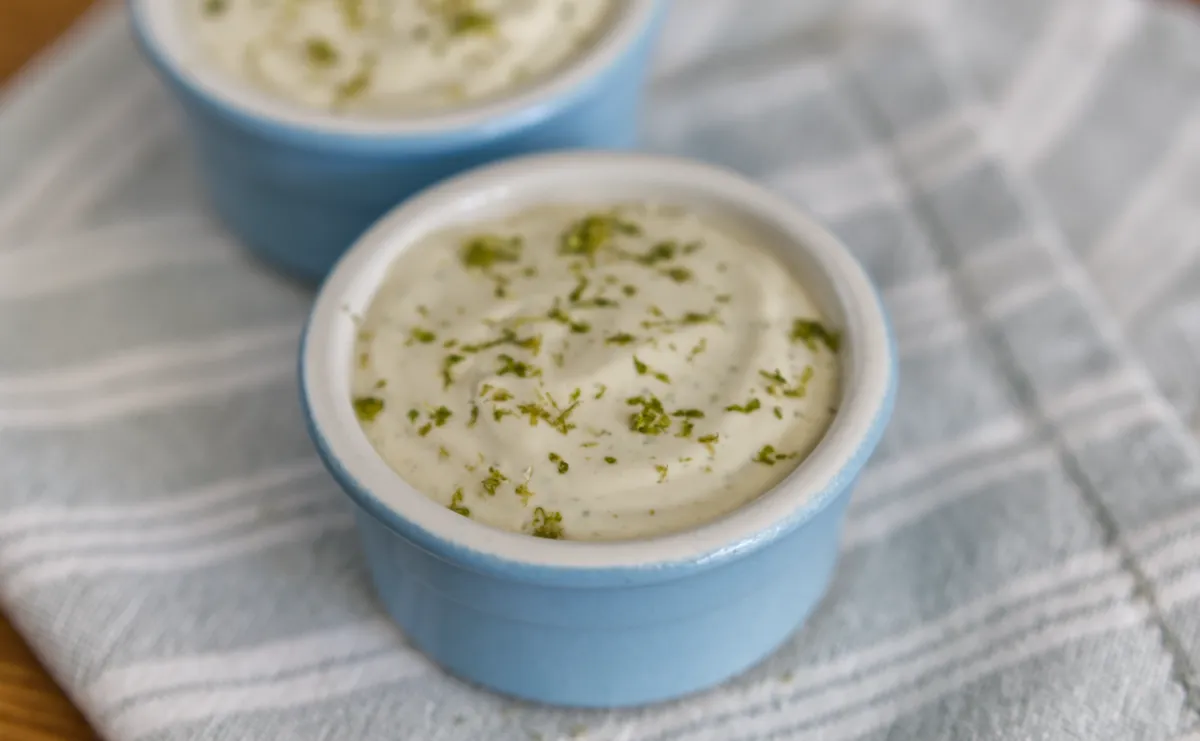 Creamy lime mousse in blue ceramic ramekins on cloth