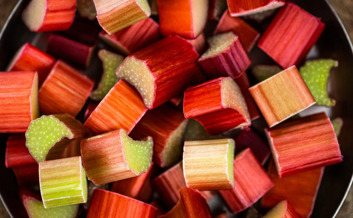 A saucepan full of chopped up pink and green rhubarb