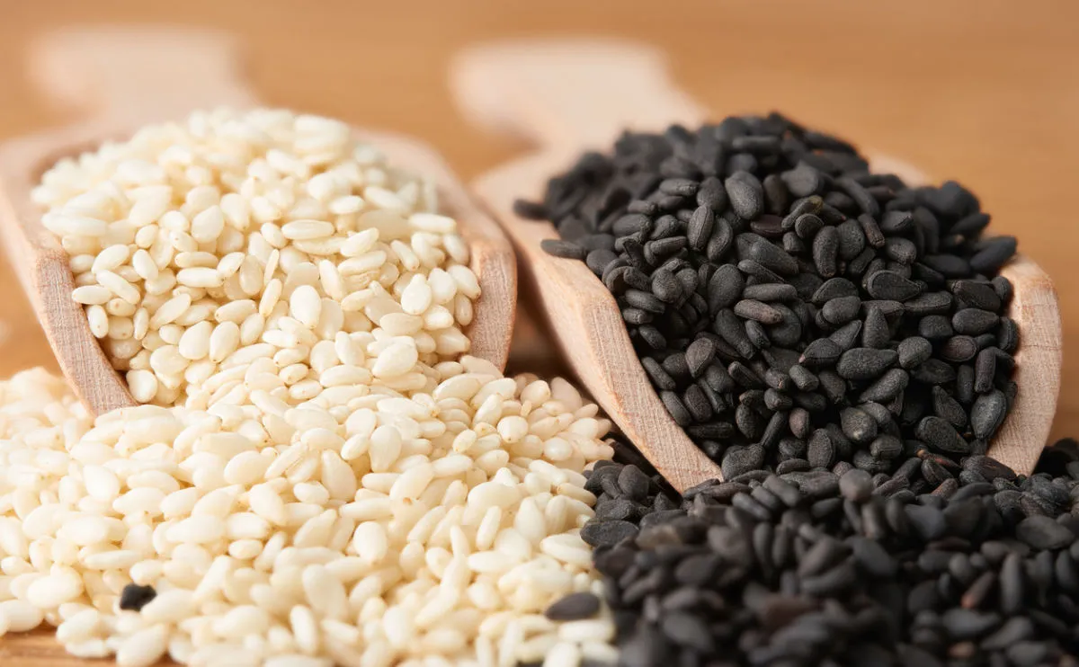 black and white sesame seeds in wooden scoops