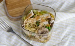 Glass pot with chicken, noodles, peas, mushrooms, and vegetables